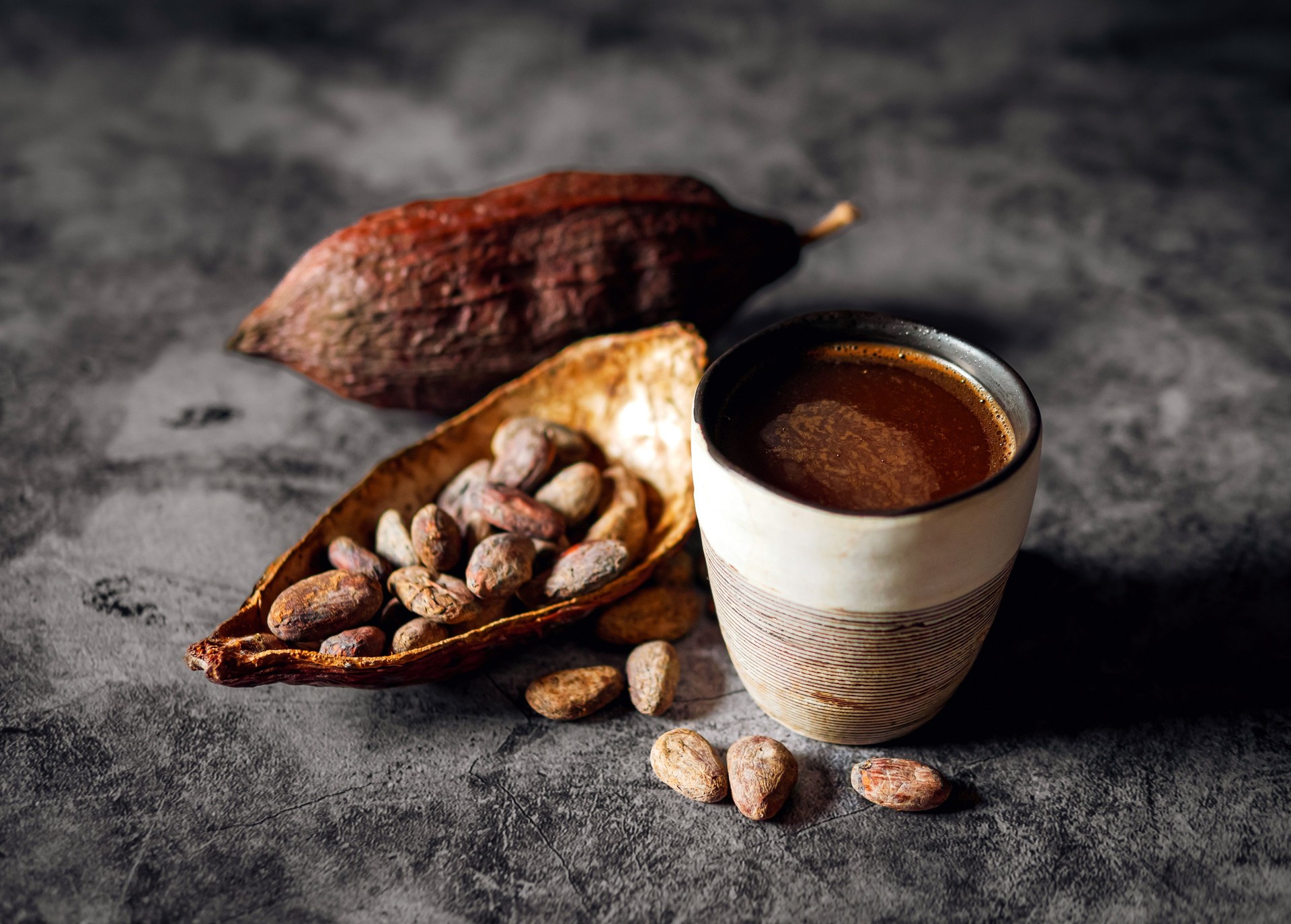 Natural craft cocoa drink, organic healthy chocolate drink with brown cocoa beans and dry cacao pod